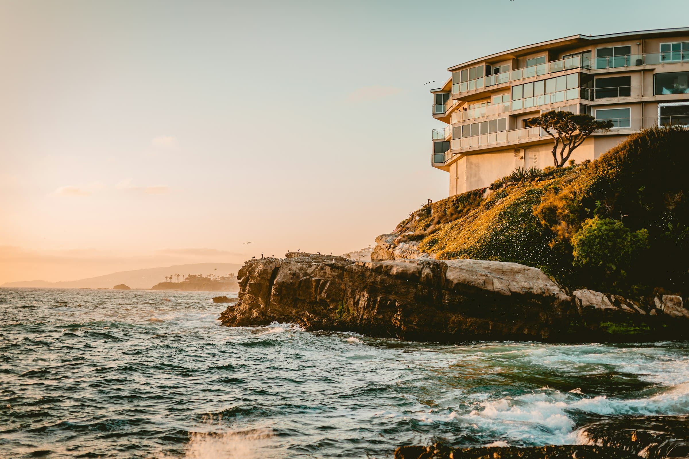 A coastal house on a bluff above the Pacific at golden hour, in the character of greater Los Angeles and Palos Verdes.